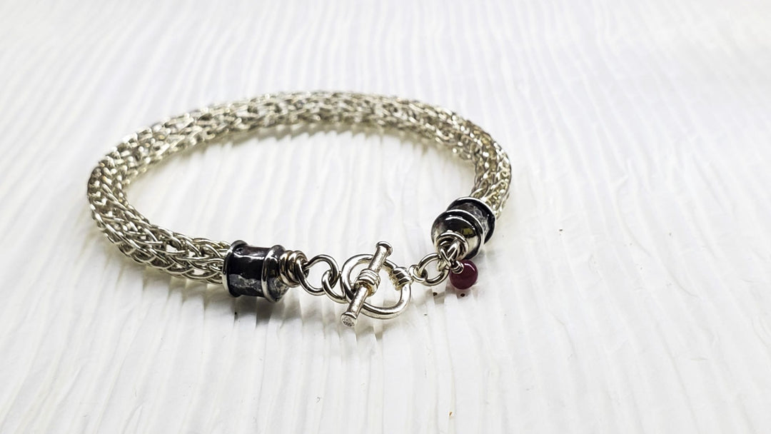 AMD1266Handmade 10mm Silver Viking Knit Bracelet with Ruby CharmJewelryBracelet$ 190.00Alexa Martha Designs