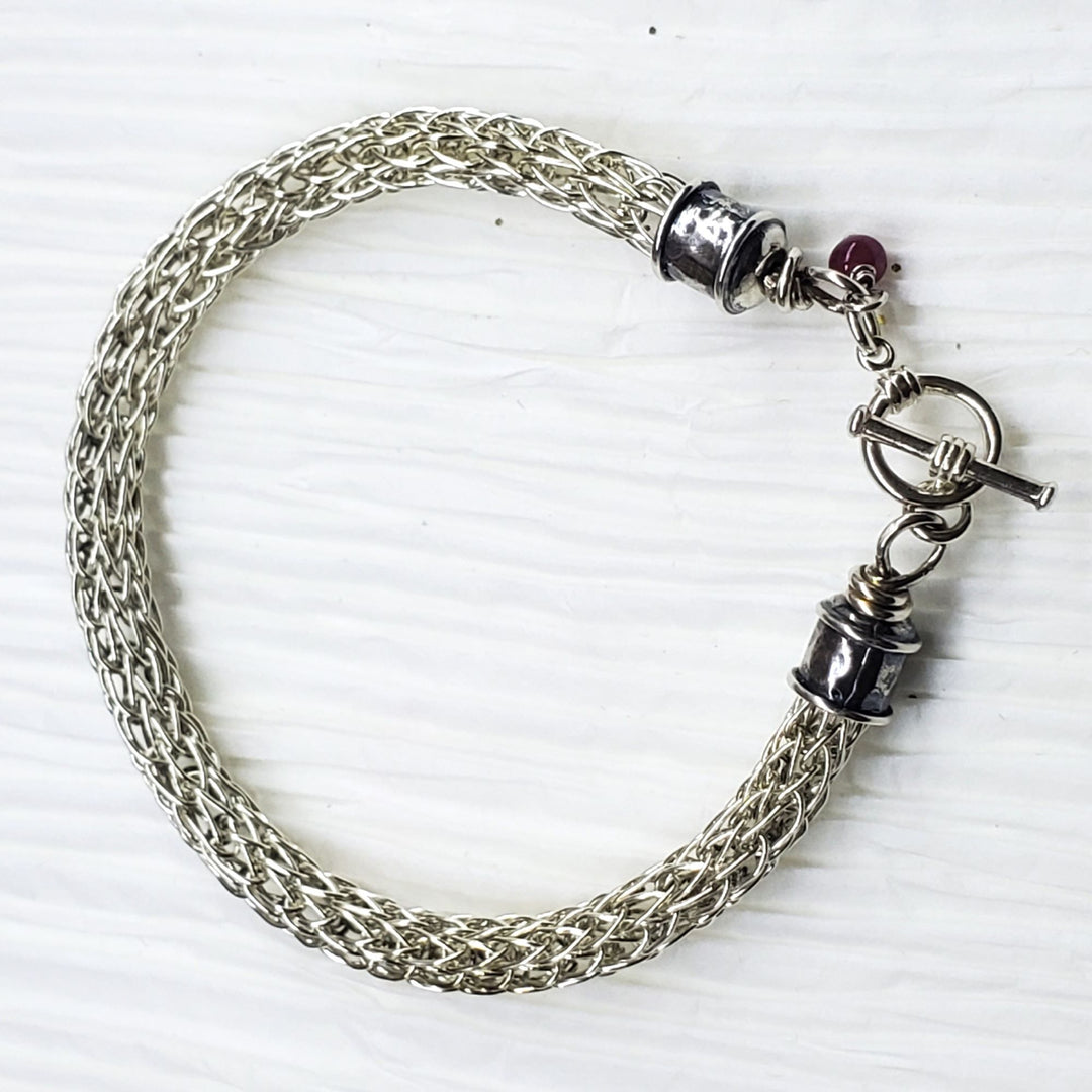AMD1266Handmade 10mm Silver Viking Knit Bracelet with Ruby CharmJewelryBracelet$ 190.00Alexa Martha Designs