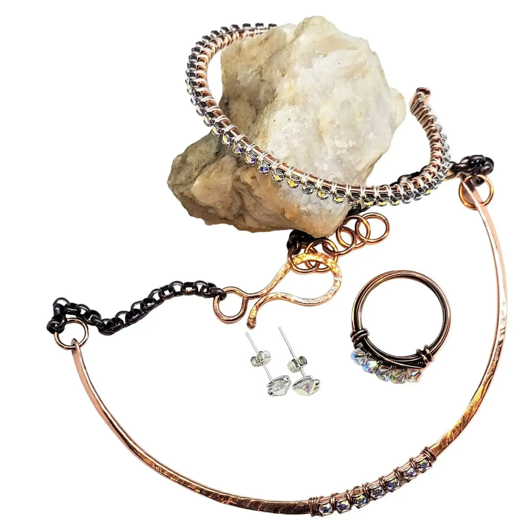 Handmade 7-year anniversary Copper Crystal Choker Set with earrings and ring on a rock.