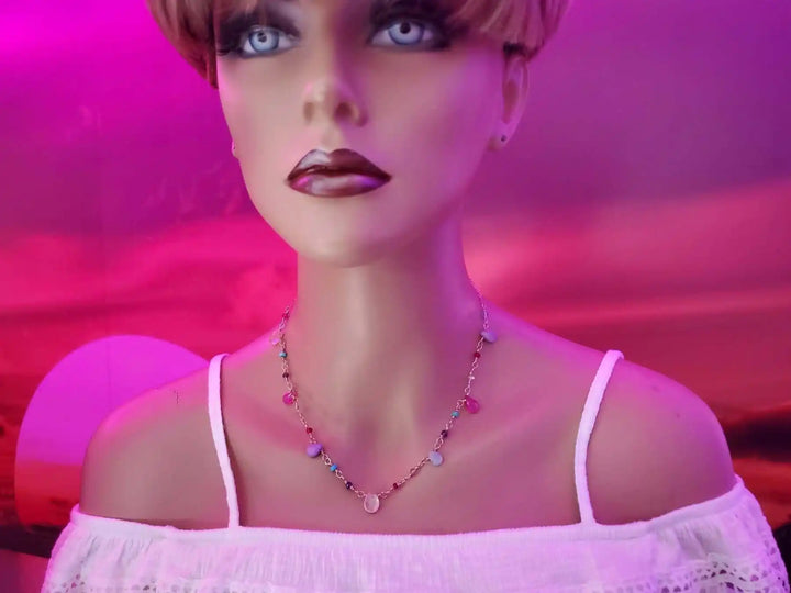Adjustable Golden Wire Wrapped Kunterbunt Gemstone Necklace displayed on a mannequin against a vibrant sunset background.
