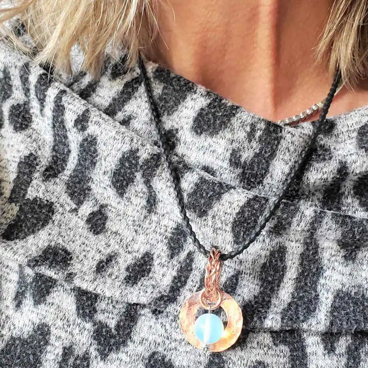 Handmade copper wire braided bail gemstone necklace featuring a rare Luminite gemstone on a model&