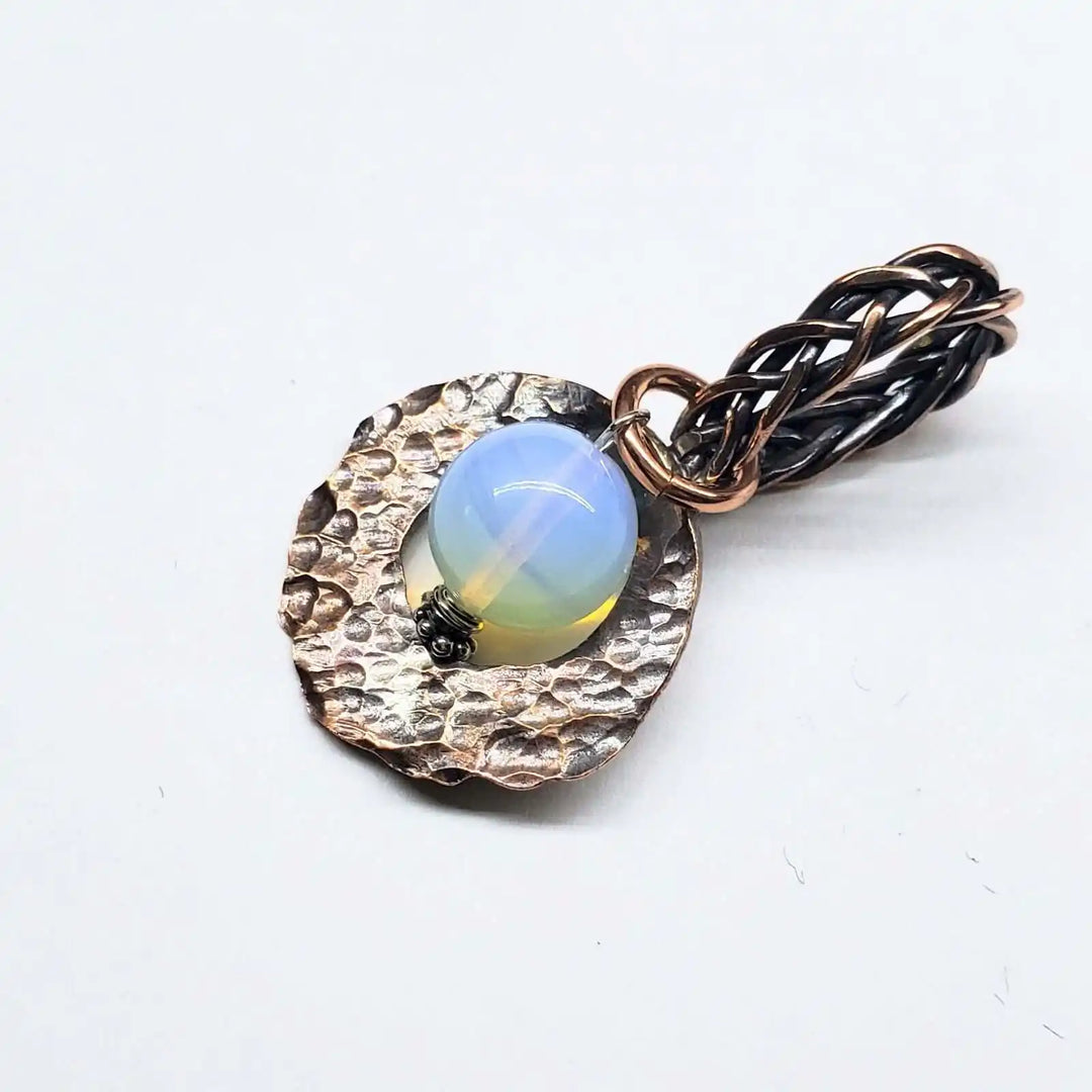 Handmade copper wire braided bail gemstone necklace featuring a Luminite gemstone on a textured backdrop.