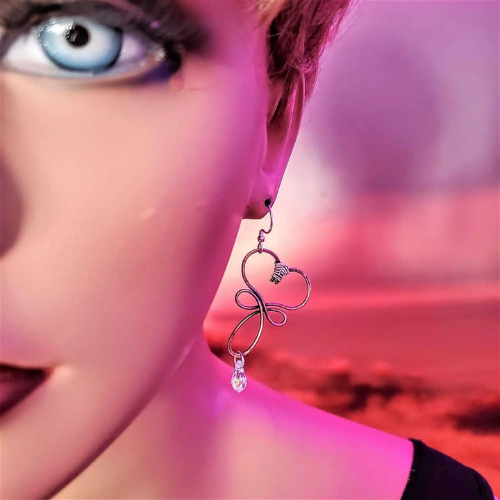 Handmade Copper Wire Sculpted Heart Crystal Drop Earrings worn by a model with dramatic makeup and striking blue eyes.