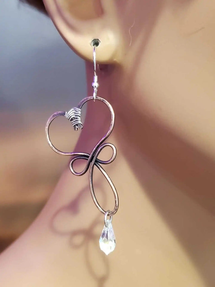 Handmade Copper Wire Sculpted Heart Crystal Drop Earrings displayed on a mannequin ear showcasing their elegant design.