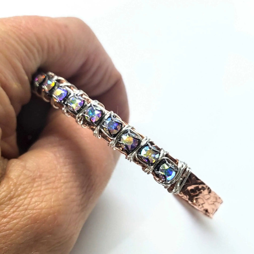 Hand wearing a Silver Wire Wrapped Crystal Textured Copper Cuff Set showcasing rhinestone details and artisan craftsmanship.
