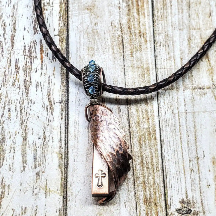 Sculpted Copper Angelwing Crystal Birthstone Necklace featuring a handcrafted copper angel wing and crystal on a braided cord.