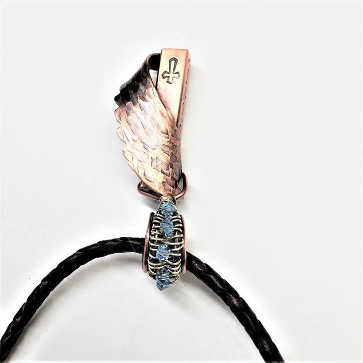 Sculpted Copper Angelwing Crystal Birthstone Necklace featuring a copper wing pendant and blue Swarovski crystal.