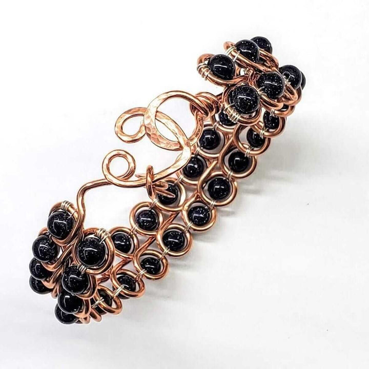 Wire Sculpted Blue Beaded Infinity Child Abuse Bangle showcasing intricate copper design with blue sandstone beads.