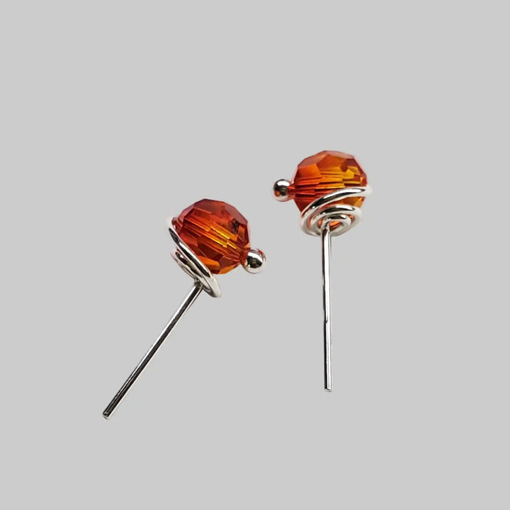 Handmade 6mm Silver Spiral Crystal Stud Earrings featuring orange Swarovski crystals in a spiral design.