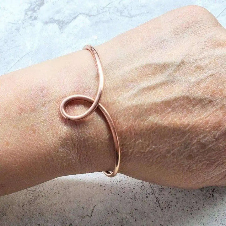 Handmade Sculpted Copper Teardrop Bangle worn on wrist, featuring a unique teardrop design in sturdy copper.