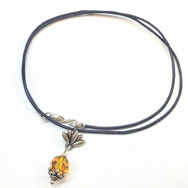 Handmade silver crystal pineapple leather necklace with a yellow crystal pendant on black leather cord.