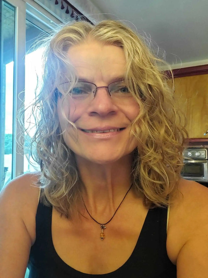 Handmade silver crystal pineapple leather necklace worn by a woman with curly hair and glasses.