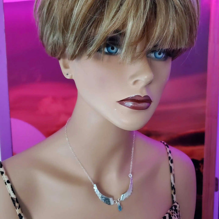 Handmade Silver Forged Sculpted Angel Wings Necklace worn by a mannequin with blue eyes and stylish hair.