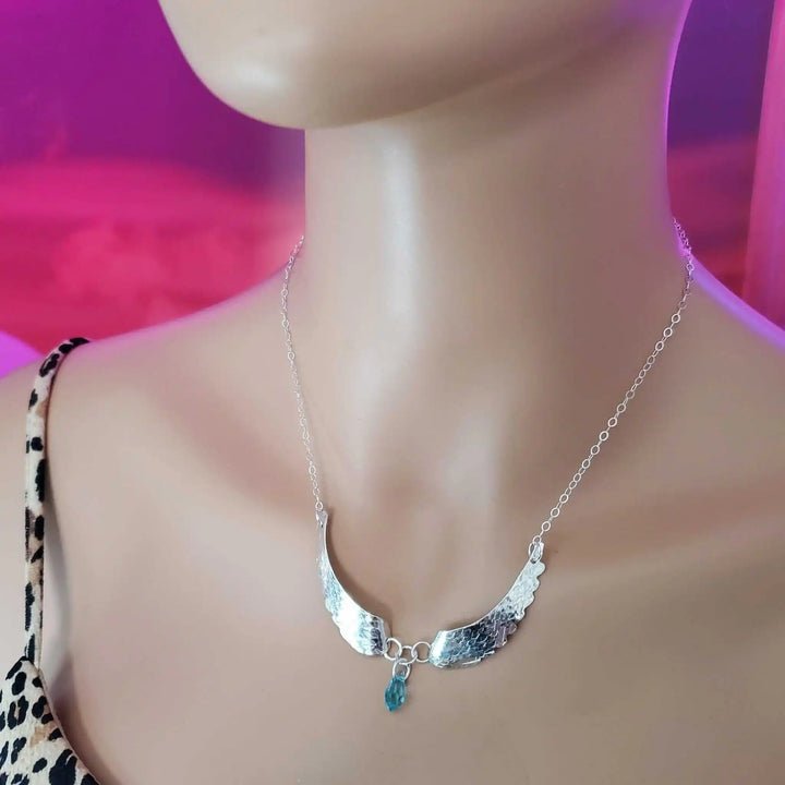 Handmade Silver Forged Sculpted Angel Wings Necklace worn on a mannequin, featuring Swarovski crystal teardrop.