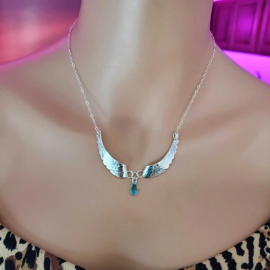 Handmade Silver Forged Sculpted Angel Wings Necklace displayed on a mannequin, featuring shimmering Swarovski crystal teardrop.