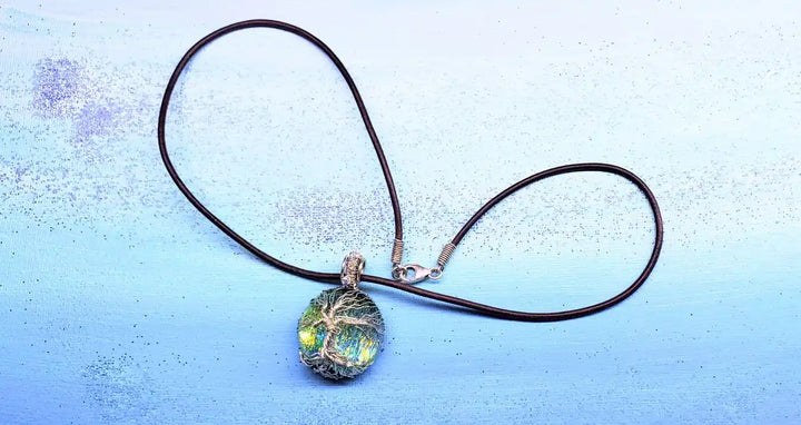 Handmade Tree of Life Dichroic Pendant Necklace featuring a colorful glass cabochon and a leather cord.
