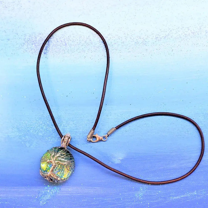 Handmade Tree of Life Dichroic Pendant Necklace on a leather cord with a color-shifting glass cabochon.