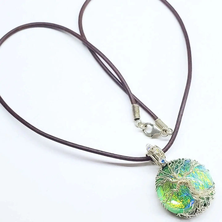Handmade tree of life dichroic pendant necklace featuring vibrant shifting colors and silver wrap design.