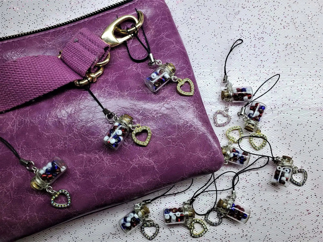 Handmade Silver Wire Wrapped Red White Blue Bottle Charm on a purple purse with heart charms
