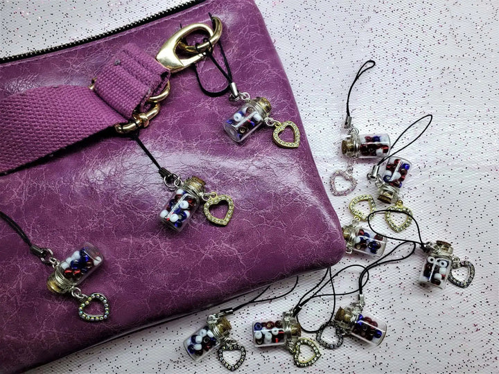 Handmade Silver Wire Wrapped Red White Blue Bottle Charm on a purple purse with heart charms