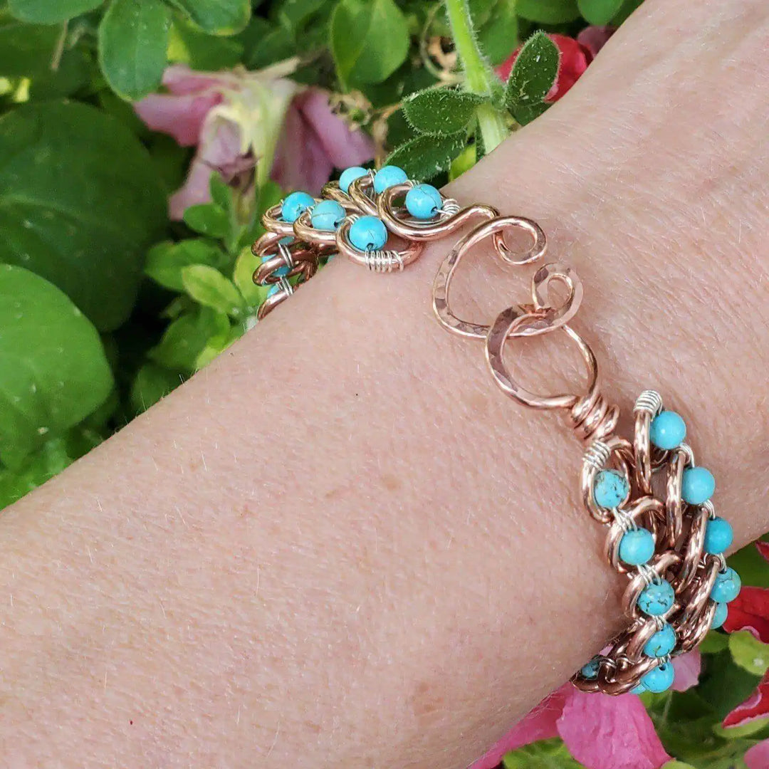 Wire Wrapped Turquoise Copper Infinity Heart Closure Bangle on wrist with turquoise and copper design