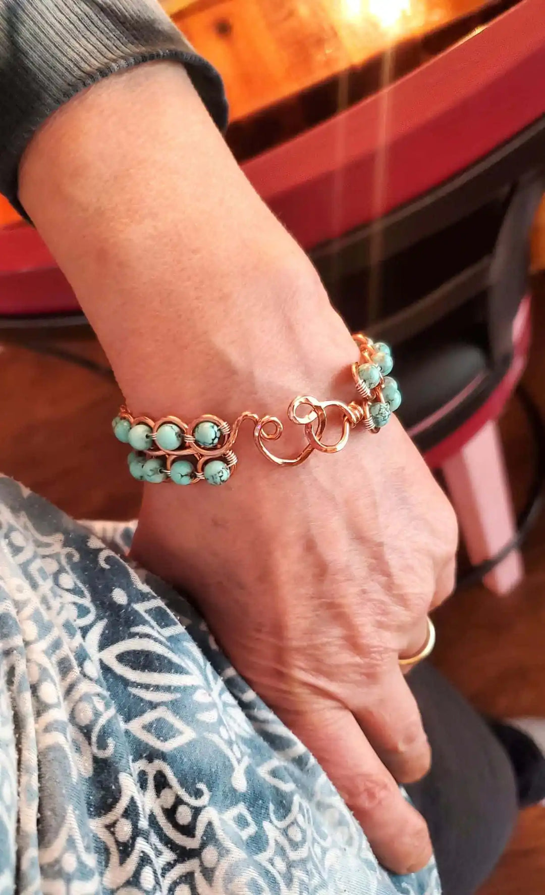 Wire Wrapped Turquoise Copper Infinity Heart Closure Bangle worn on a wrist showcasing its bohemian elegance.