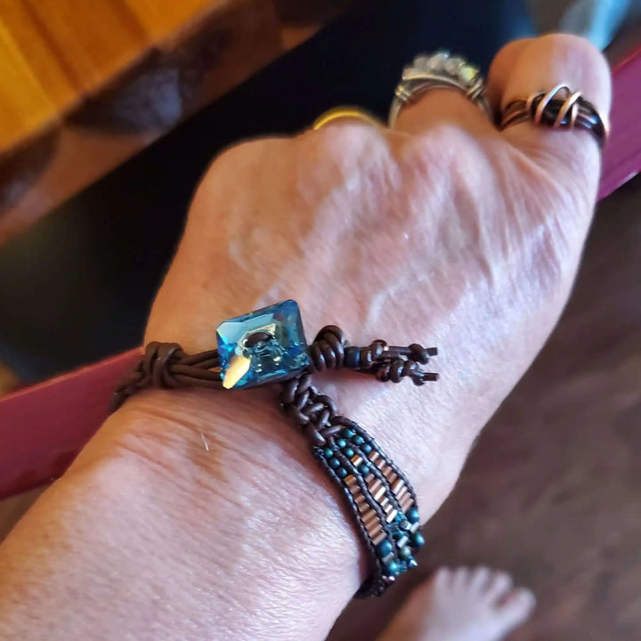 Intricate Bead Woven Swarovski Crystal Button Glam Bracelet showcasing aqua crystal on a hand.