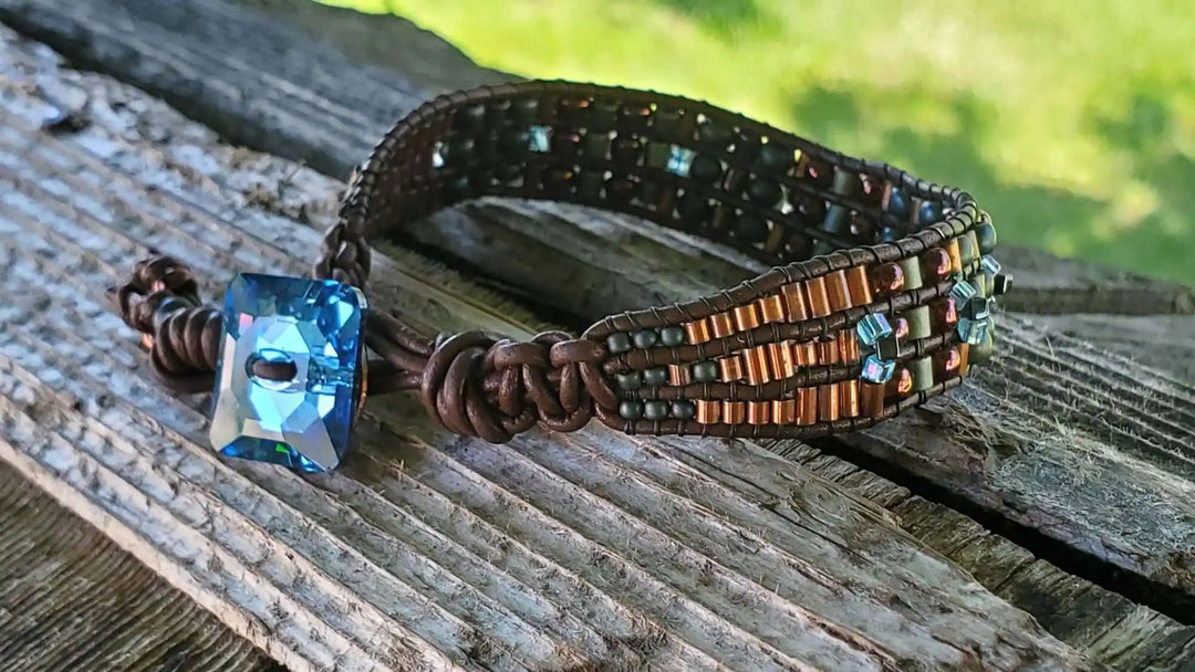 Intricate Bead Woven Swarovski Crystal Button Glam Bracelet showcasing a large aqua crystal on a woven leather band.