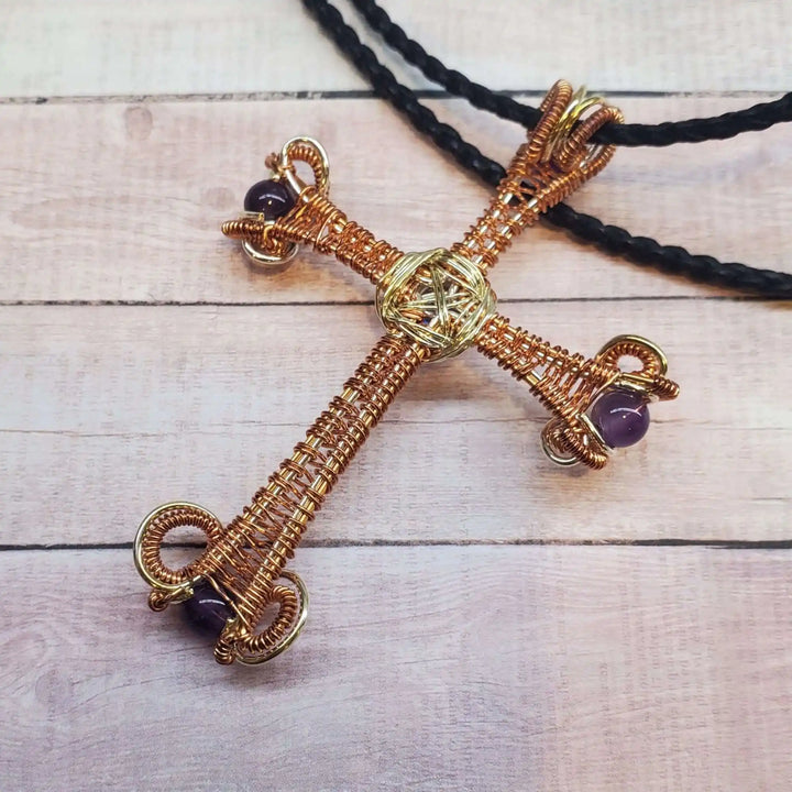 Large Wire Woven Copper Silver Amethyst Cross Necklace showcased on a wooden background with a braided cord.