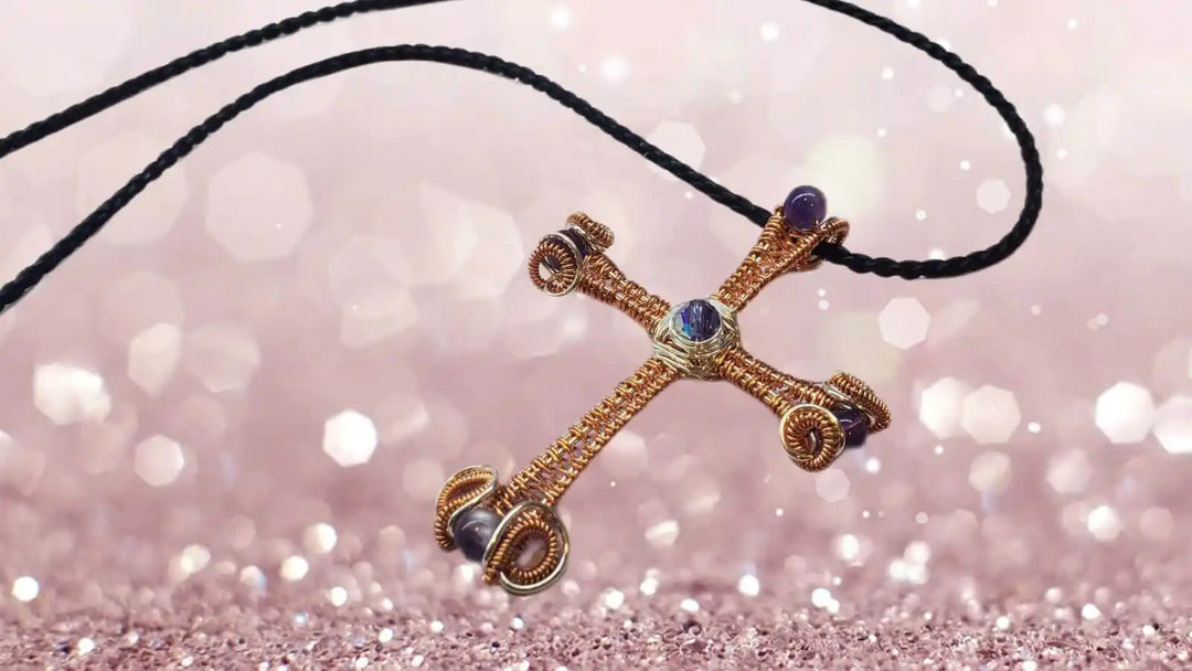 Large Wire Woven Copper Silver Amethyst Cross Necklace on a black cord against a sparkling background.