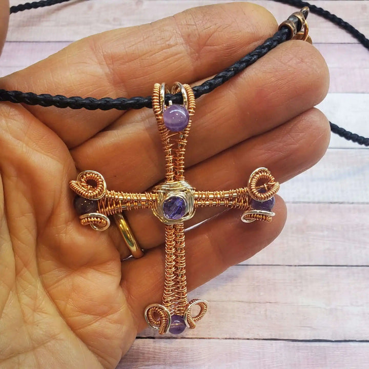 Large Wire Woven Copper Silver Amethyst Cross Necklace held in hand, showcasing intricate craftsmanship and design.