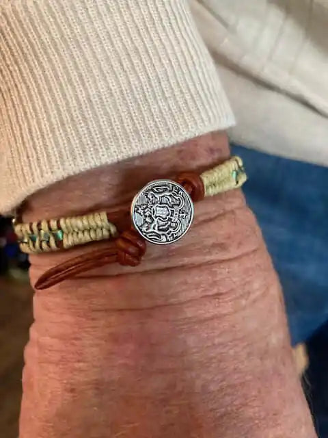 Leather Seed Bead Rattlesnake Tail Weave Bracelet displayed on a wrist with a silver charm.