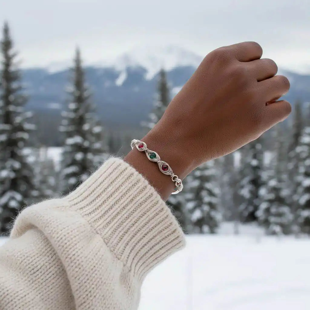 Limited Edition Red Green Christmas Holiday Tube Bracelet worn on a hand, set against a snowy mountain backdrop.