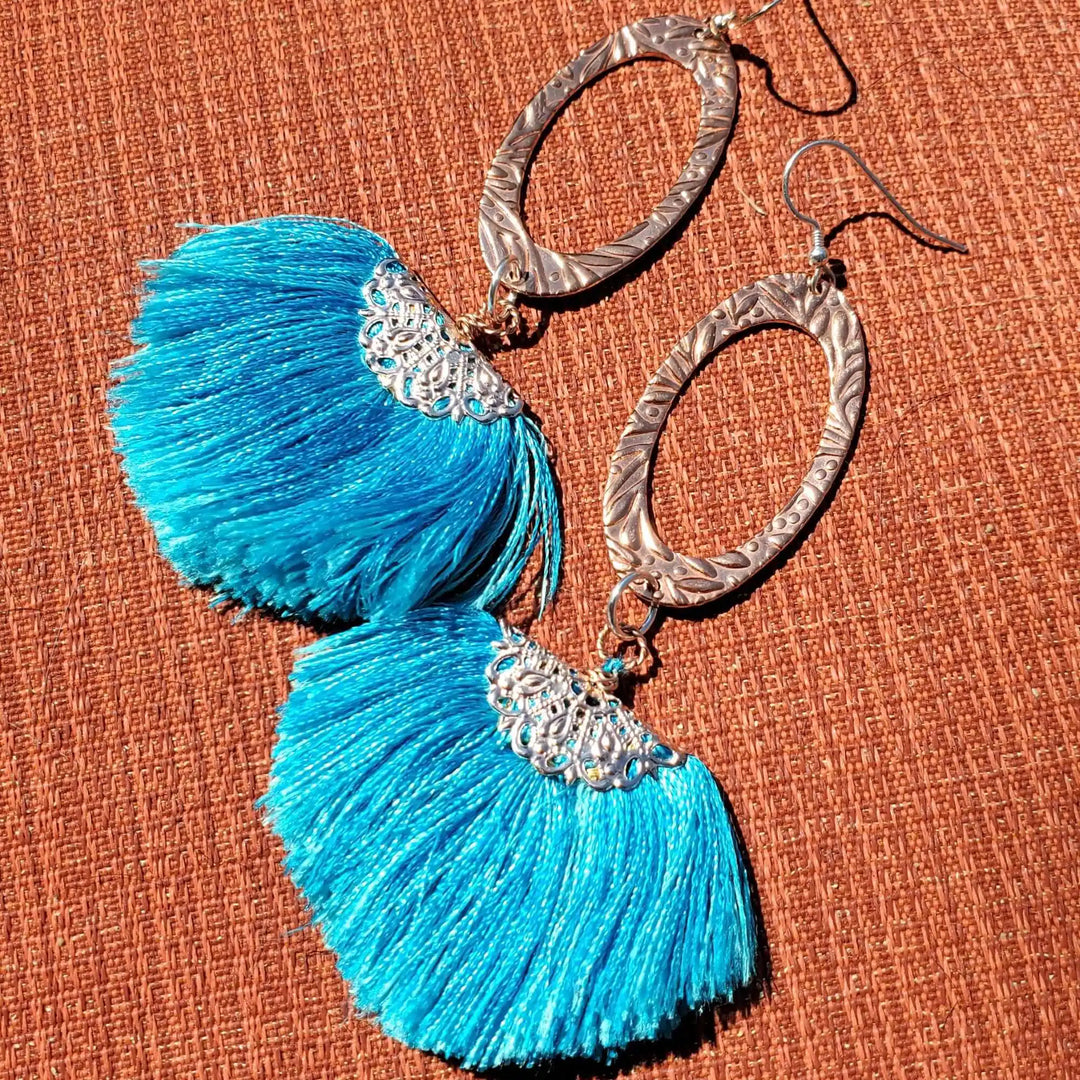 Long Copper Embossed Aqua Brushed Silk Fan Tassel Earrings with vibrant aqua tassels and intricate metalwork.