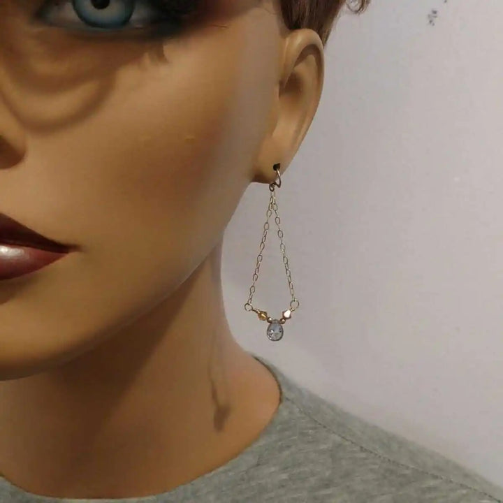 mystic rainbow quartz drop gold filled earrings showcased on a mannequin, featuring a beautiful drop design with shimmering gemstones.