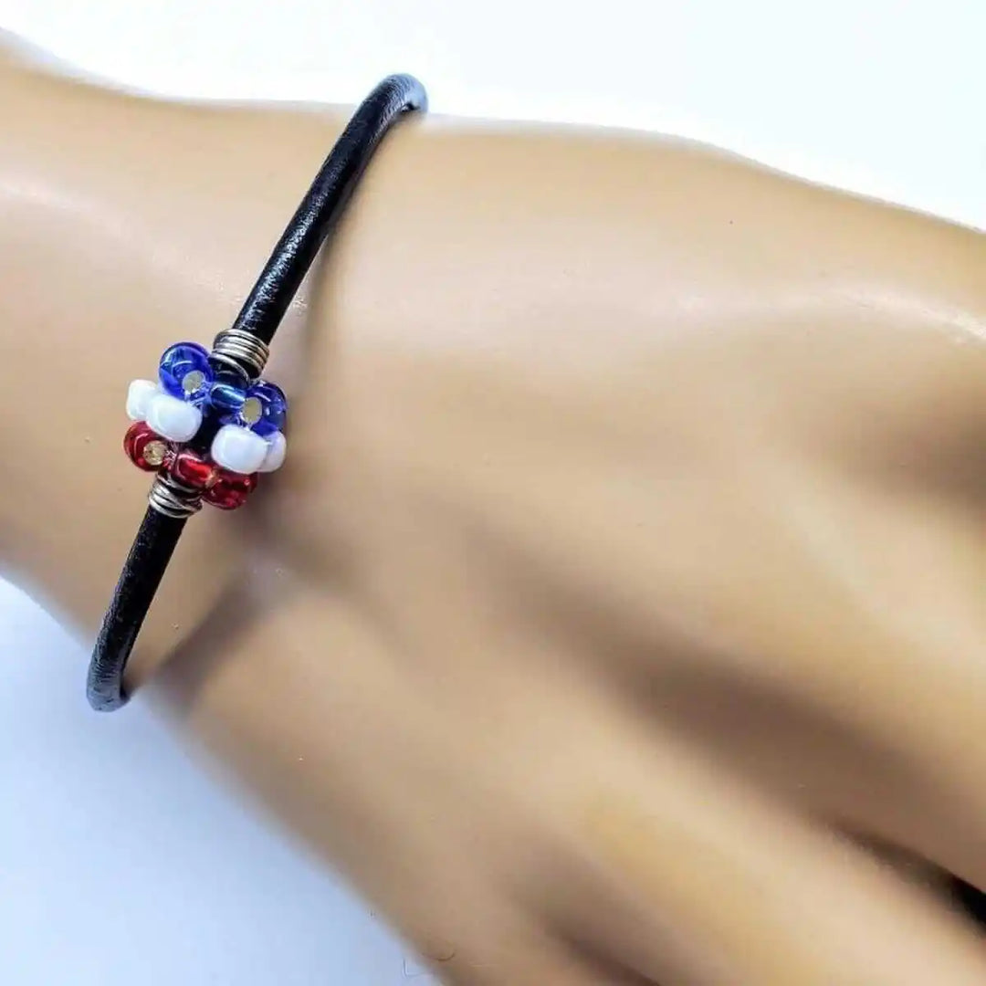 Patriotic Red White Blue Beaded Bead Leather Bracelet on a hand showcasing its vibrant colors and craftsmanship.