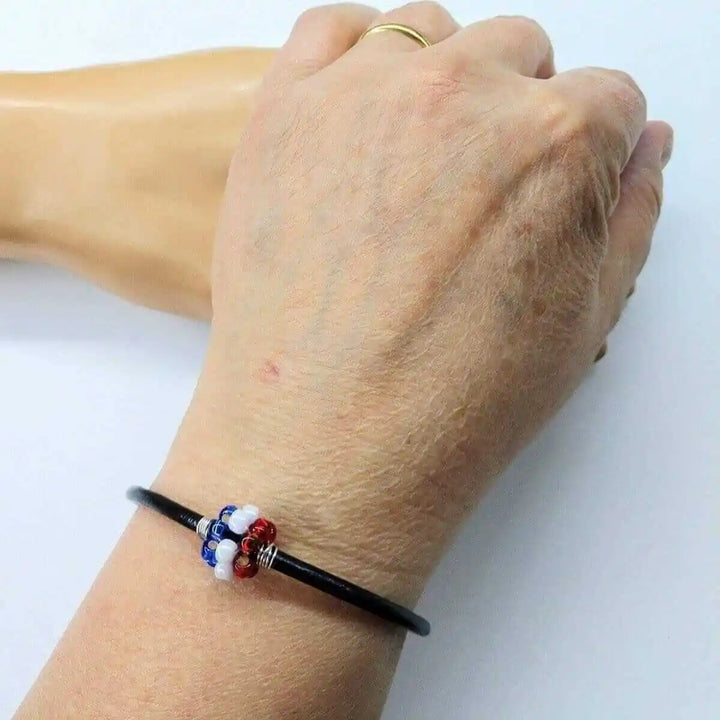 Patriotic Red White Blue Beaded Bead Leather Bracelet on hand, showcasing its artisan craftsmanship and vibrant colors.