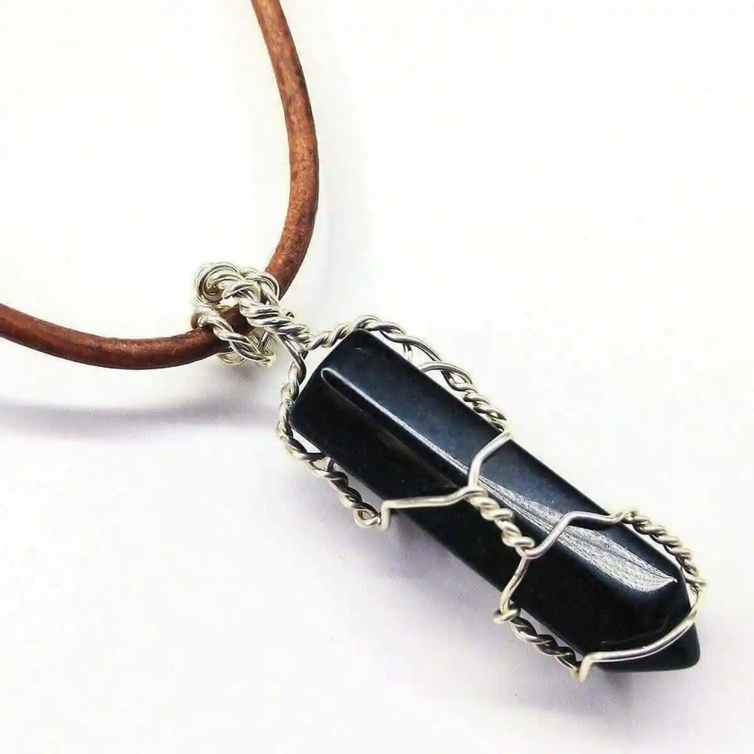 Handmade Silver Wire Wrapped Gemstone Crystal Point Pendant featuring a dark crystal encased in wire.