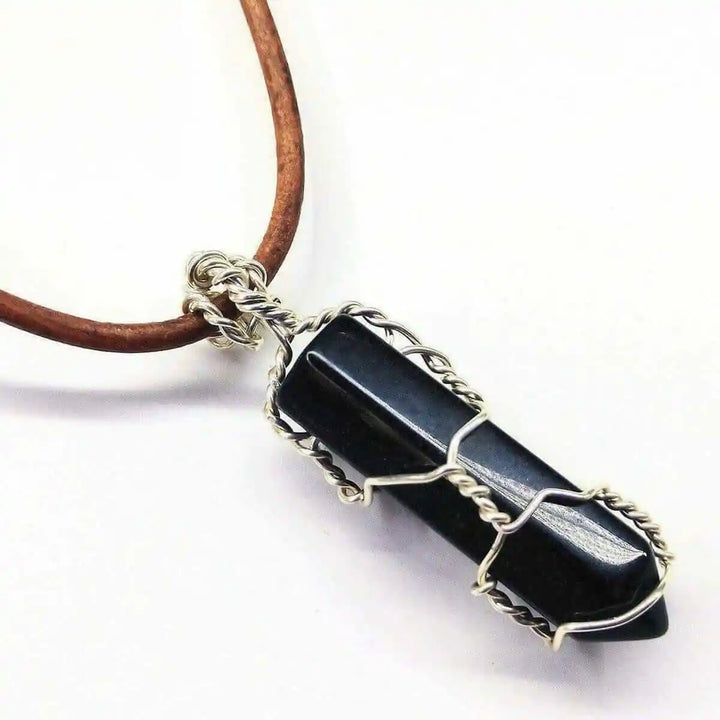 Handmade Silver Wire Wrapped Gemstone Crystal Point Pendant featuring a dark crystal encased in wire.