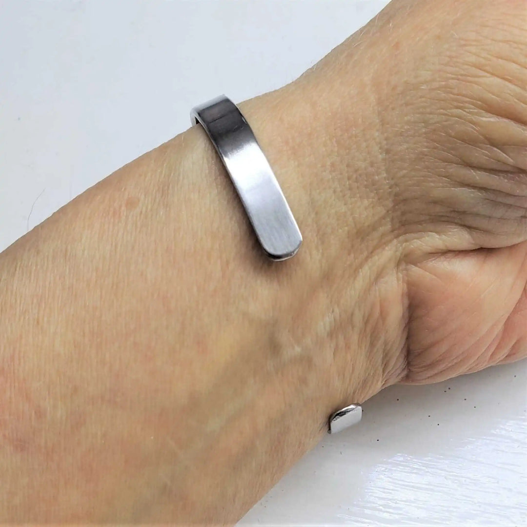 Stainless Steel LOVE Stamped Wire Wrapped Gold Druzy Cuff worn on wrist, showcasing a modern and elegant design.