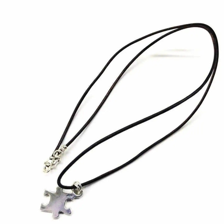 925 Silver Autism Awareness Puzzle Piece Leather Necklace on a black cord, featuring a silver puzzle piece pendant.