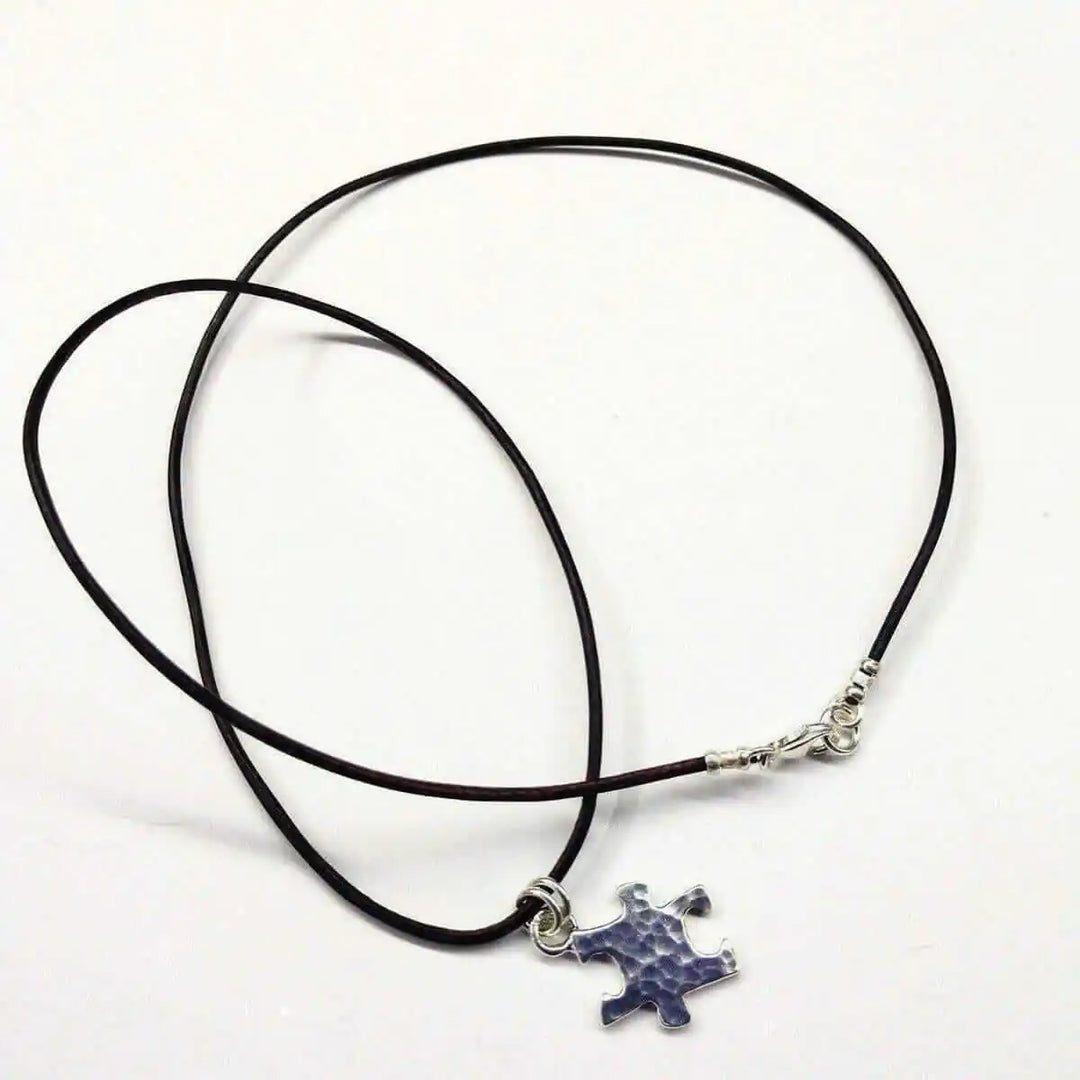 925 Silver Autism Awareness Puzzle Piece Leather Necklace featuring a rustic puzzle piece pendant on a leather cord.