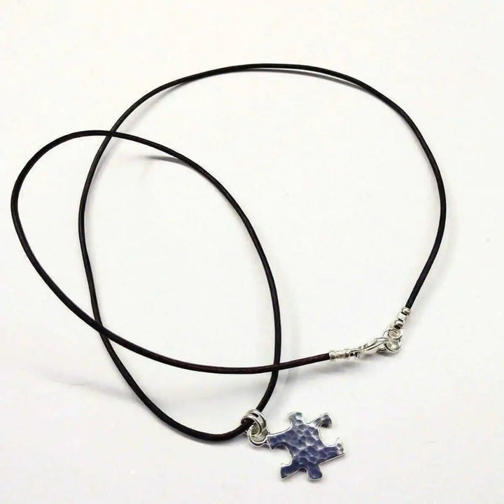 925 Silver Autism Awareness Puzzle Piece Leather Necklace featuring a rustic puzzle piece pendant on a leather cord.