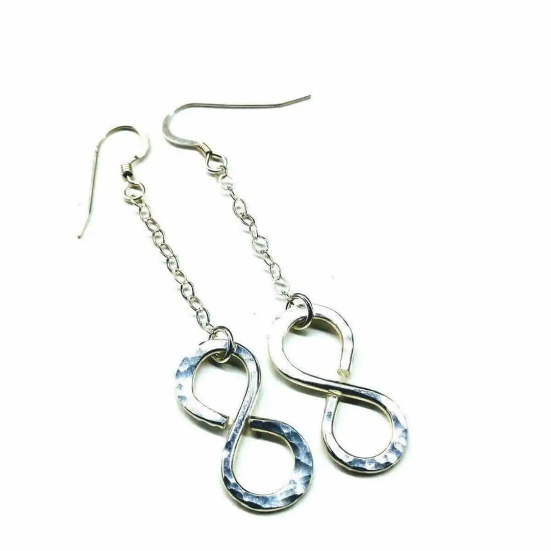 Sterling Silver Hammer Patterned Infinity Earrings hanging on a chain, showcasing their elegant design and artisan craftsmanship.