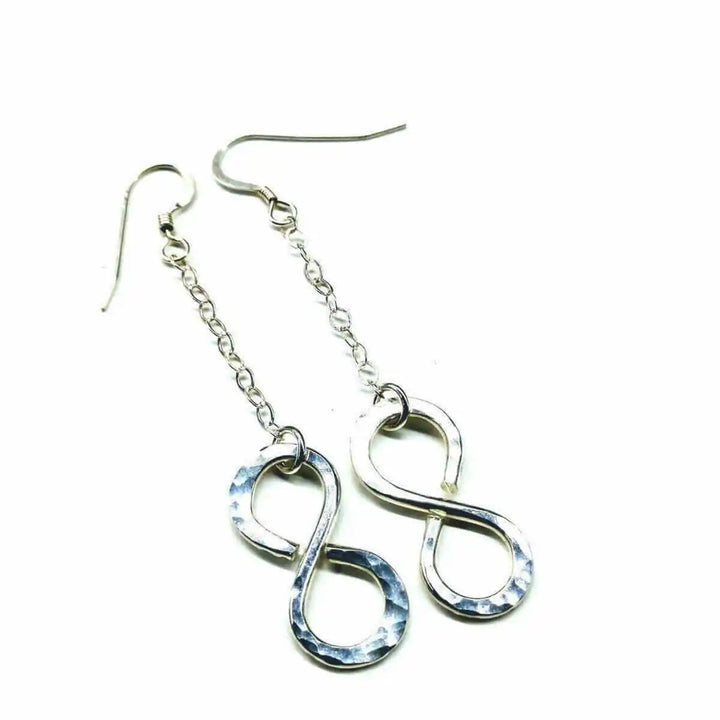 Sterling Silver Hammer Patterned Infinity Earrings hanging on a chain, showcasing their elegant design and artisan craftsmanship.