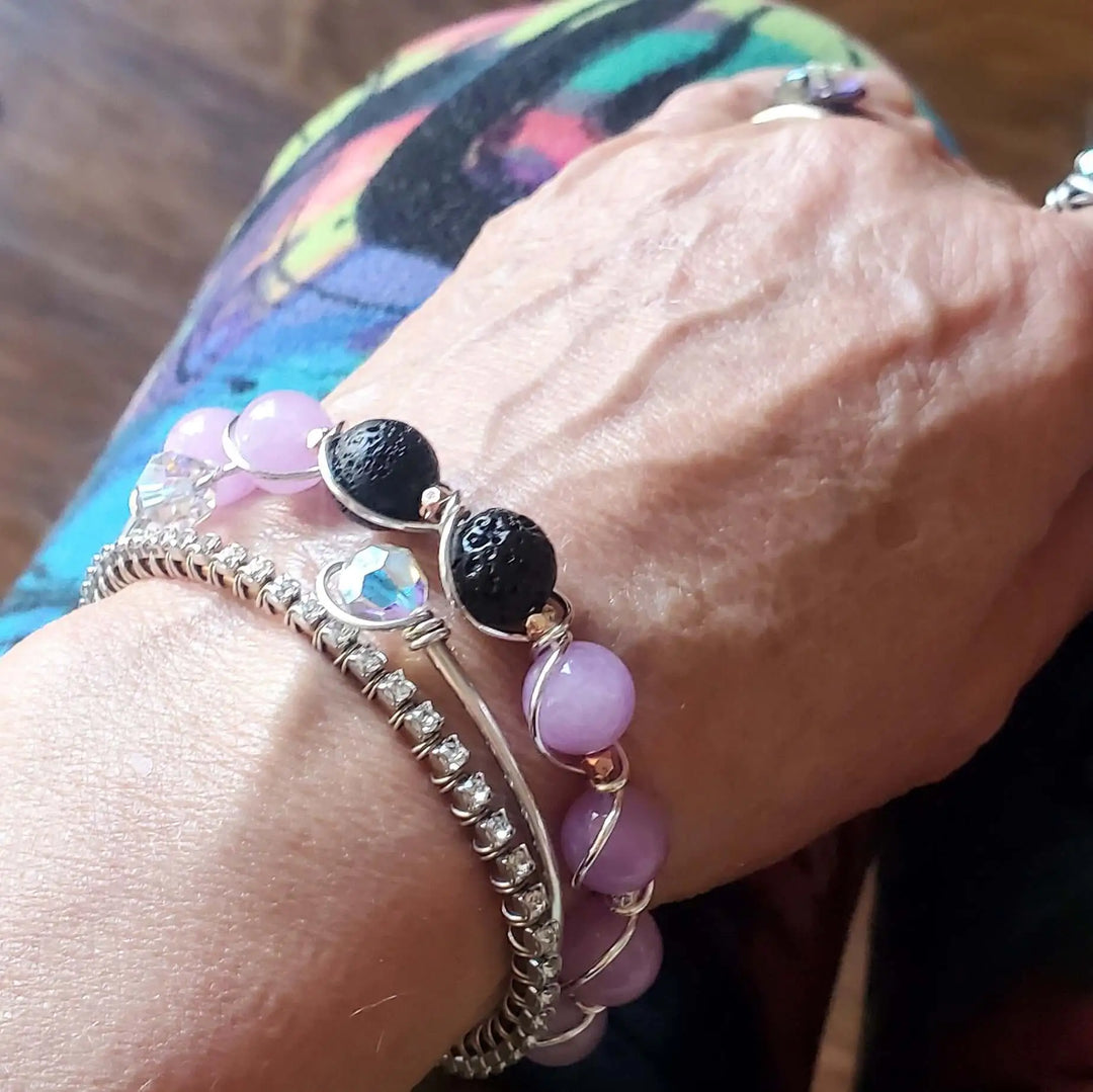 Silver Spiral Twist Wrap Purple Lava Rock Bangle Bracelet worn on wrist with colorful background.