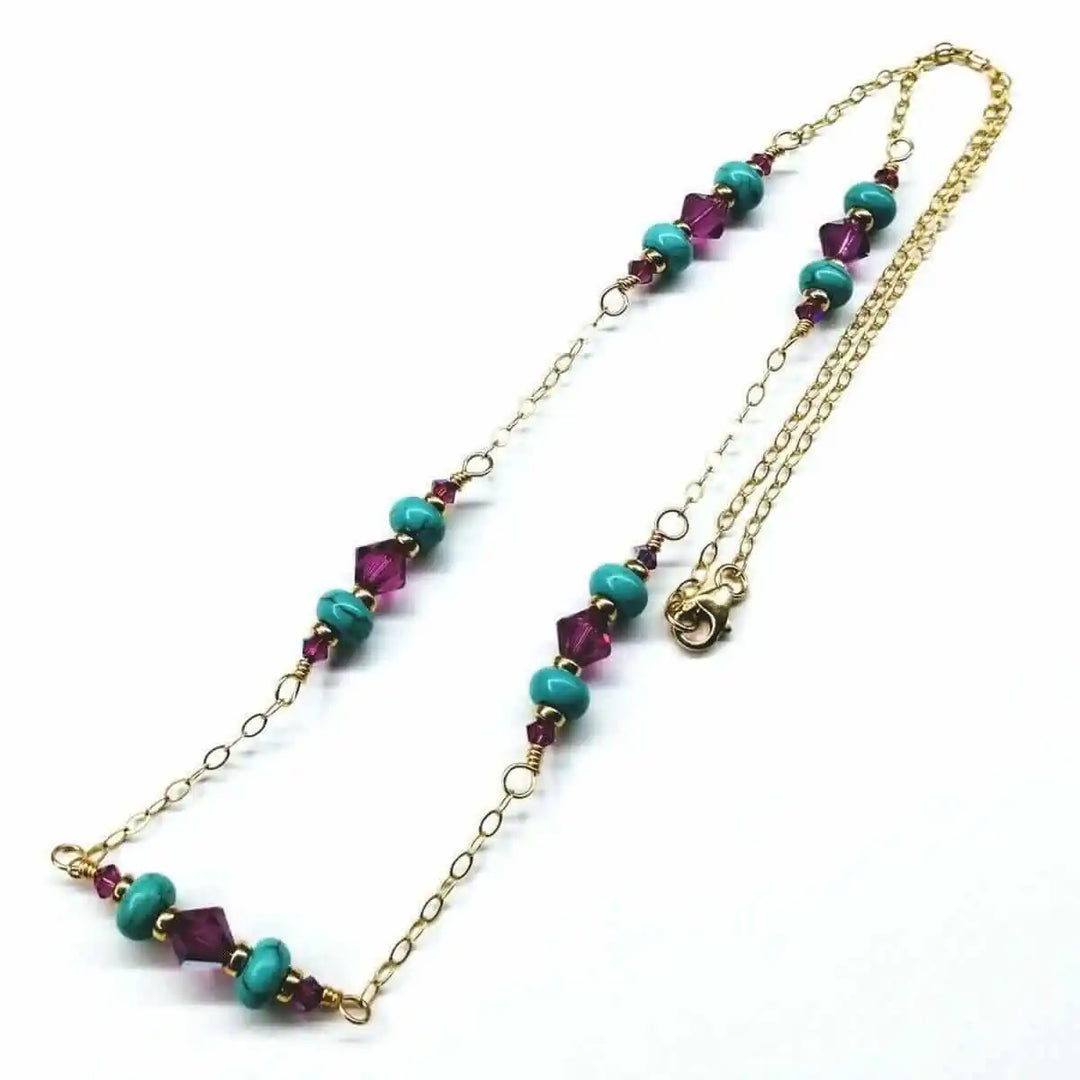 Wire Wrapped Gold Filled Pink Turquoise Gemstone Necklace with turquoise beads and fuchsia crystals on a gold chain.