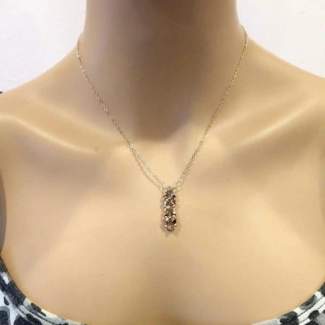 Super Sparkly Rose Gold Rock Candy Crystal Bar Necklace showcased on a mannequin with a delicate chain and crystal pendant.