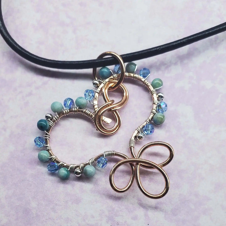 Wire Wrapped Copper Turquoise Heart Infinity Charm Necklace featuring turquoise beads and Swarovski crystals.