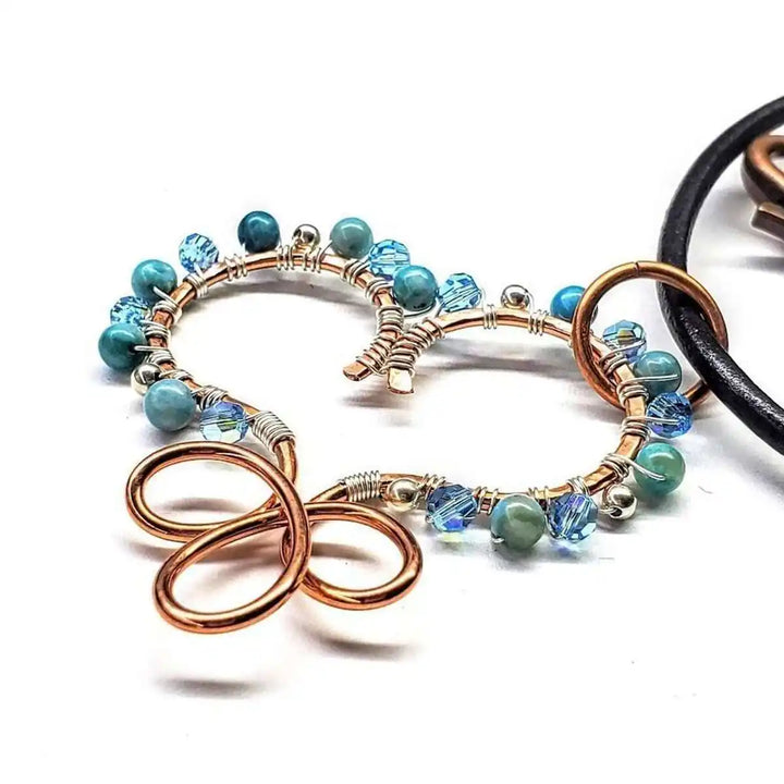 Wire Wrapped Copper Turquoise Heart Infinity Charm Necklace showcasing a hand-sculpted copper heart with turquoise beads.